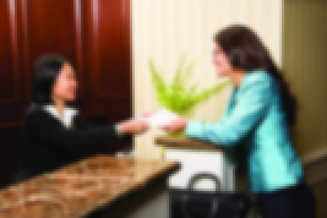 Smiling hotel receptionist helping a guest